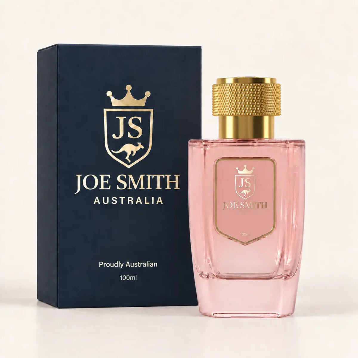 Joe Smith 100 ml pink perfume bottle with gold cap beside its navy presentation box