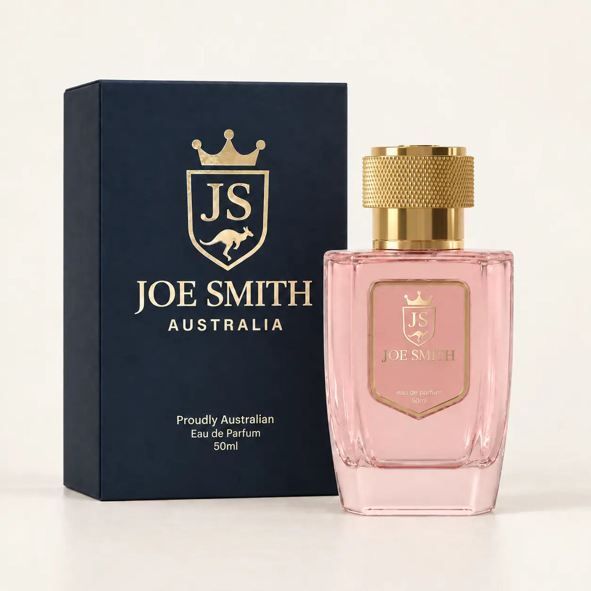 Joe Smith 50 ml pink perfume bottle with gold cap beside its navy presentation box