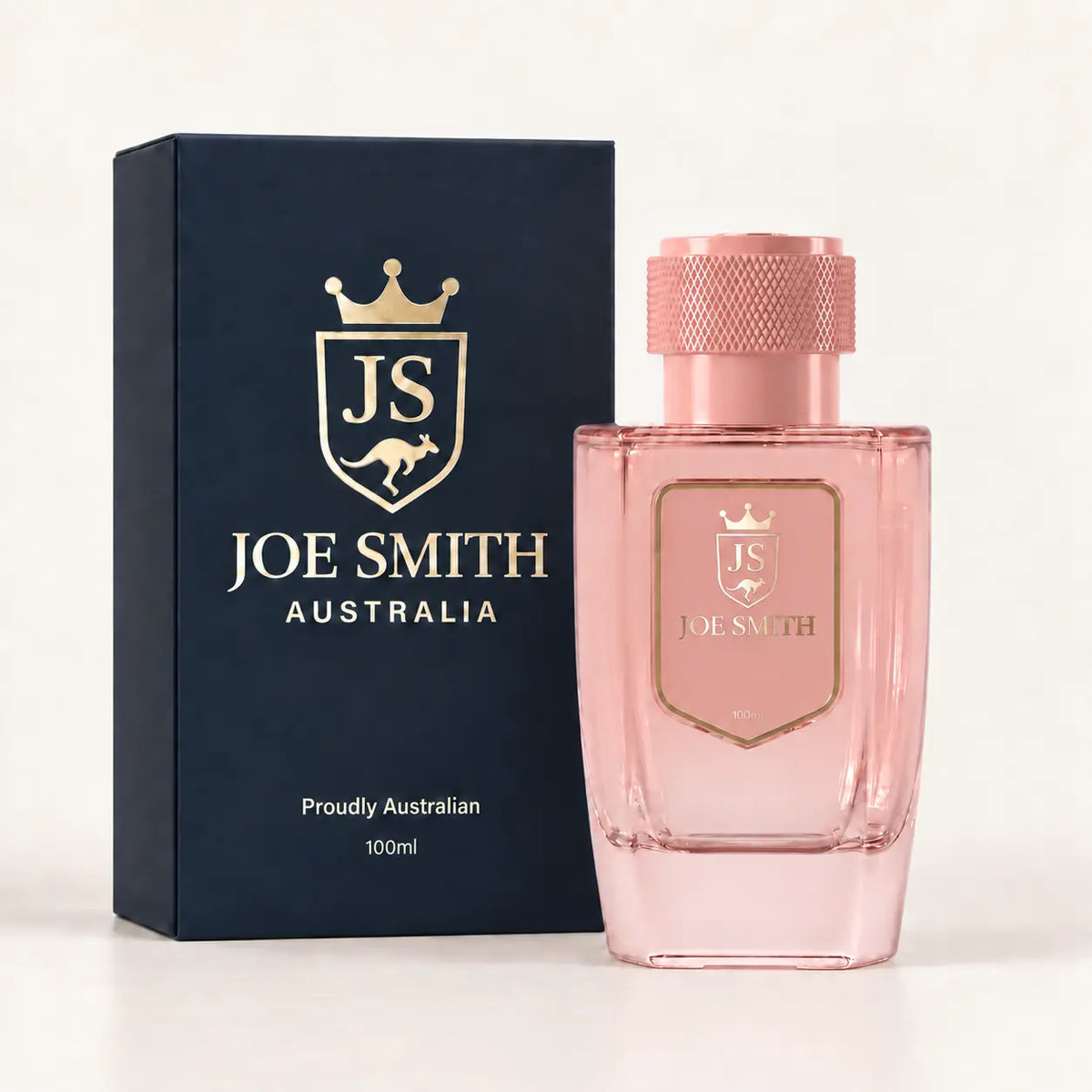 Joe Smith 100 ml pink perfume bottle with pink cap beside its navy presentation box